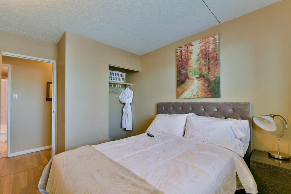 Furnished bedroom and closet in a unit at 243 Queen Street.