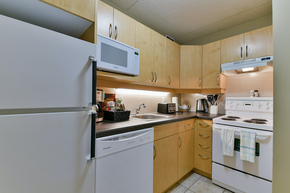 Kitchen with all appliances in a unit at 243 Queen Street.